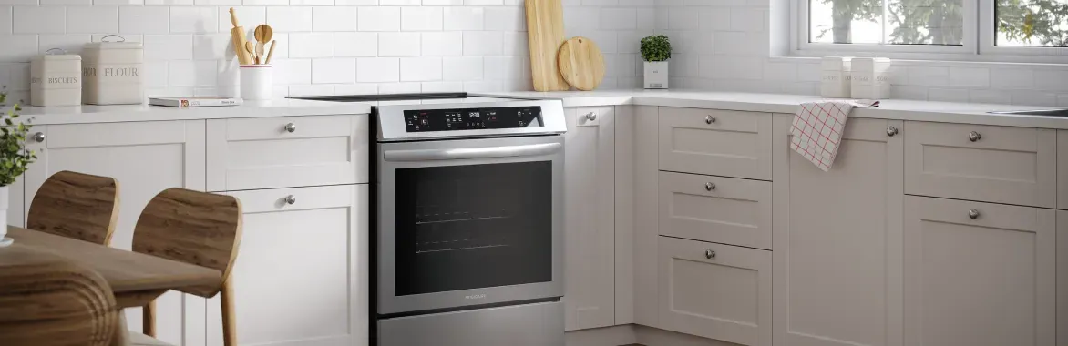 Stainless steel Frigidaire 30-inch front control induction range (FCFI3083AS) installed in a modern white kitchen.